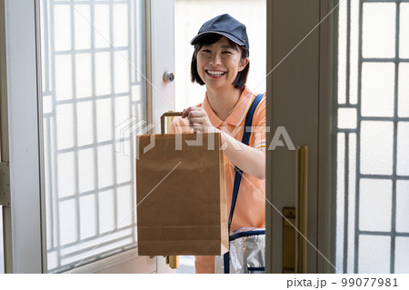 荷物を届ける若い女性 荷物を届ける若い女性 99077981