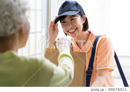 荷物を届ける若い女性 荷物を届ける若い女性 99078011