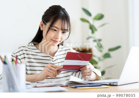 インフレで通帳を確認する女性 インフレで通帳を確認する女性 99078035