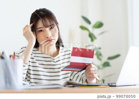 インフレで家計簿を確認する女性 インフレで家計簿を確認する女性 99078050