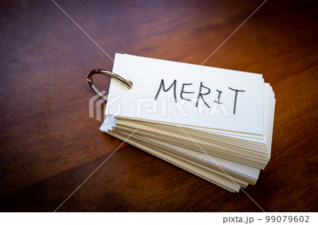 テーブルの上に置かれた単語カード　「MERIT」の文字 99079602