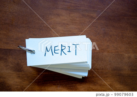 テーブルの上に置かれた単語カード　「MERIT」の文字 99079603