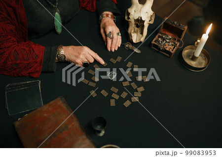 Old mature witch giving prediction using spiritual attributes closeup top view 99083953