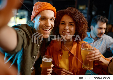 Happy friends taking selfie photo while rest at sports bar 99083959