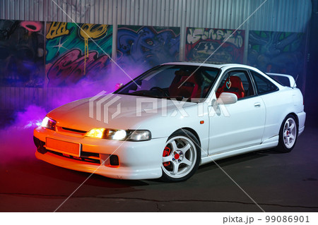 90s sport car with smoke in neon light on the asphalt road at night 90s sport car with smoke in neon light on the asphalt road at night 99086901