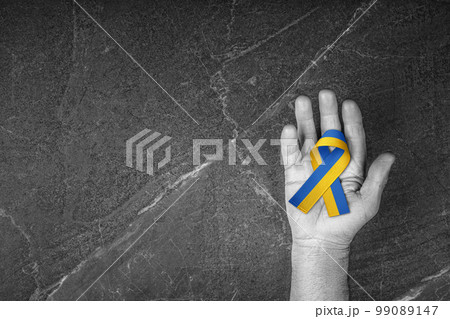 blue yellow ribbon lies on the male palm blue yellow ribbon lies on the male palm 99089147