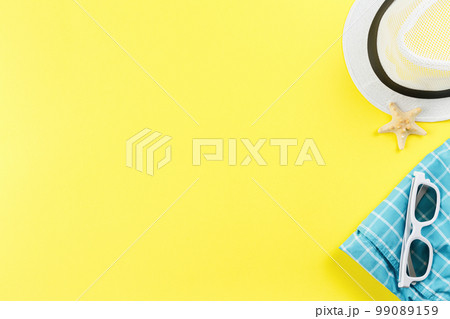 Beachwear and shellfish souvenirs on yellow background. 99089159