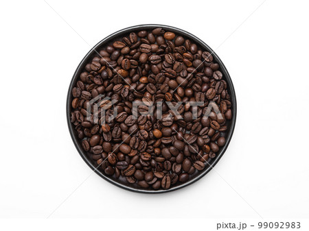 Fresh raw aroma coffee beans on round plate on white background.Top view. 99092983