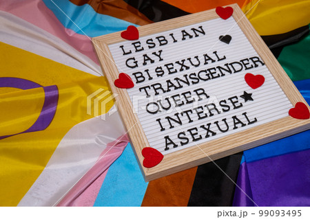 LGBTQIA description frame on Rainbow LGBTQIA flag made from silk material. LESBIAN, GAY, BISEXUAL, TRANSGENDER, QUEER, INTERSEX, ASEXUAL Symbol of LGBTQ pride month. Equal rights. Peace and freedom. LGBTQIA description frame on Rainbow LGBTQIA flag made from silk material. LESBIAN, GAY, BISEXUAL, TRANSGENDER, QUEER, INTERSEX, ASEXUAL Symbol of LGBTQ pride month. Equal rights. Peace and freedom. 99093495