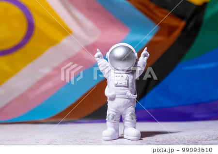 Toy astronaut on Rainbow LGBTQIA flag made from silk material background. Happy pride month. Symbol of LGBTQ pride month. Equal rights. Peace and freedom. Support LGBTQIA community Toy astronaut on Rainbow LGBTQIA flag made from silk material background. Happy pride month. Symbol of LGBTQ pride month. Equal rights. Peace and freedom. Support LGBTQIA community 99093610