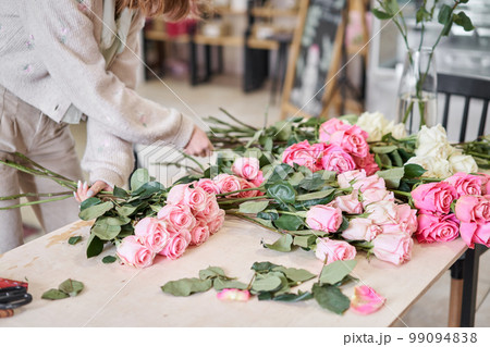 Florist prepares flowers. Fresh delivery in flower shop. European floral shop. Delivery fresh cut flower. 99094838