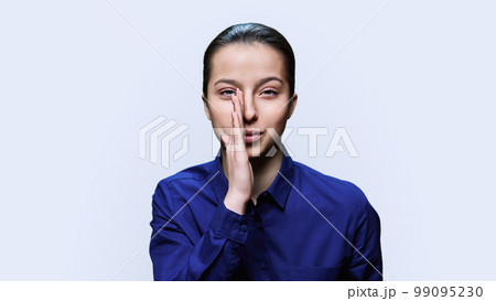 Young teenage woman whispering secret, over white background Young teenage woman whispering secret, over white background 99095230