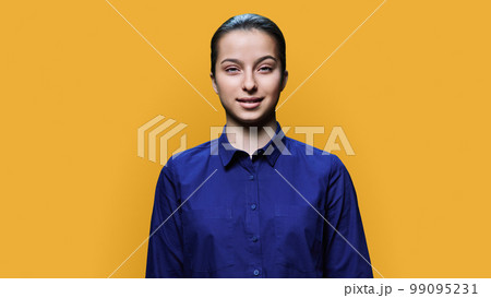 Portrait of smiling teenage girl 15, 16 years old on yellow background 99095231