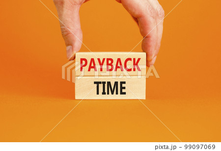 Payback time symbol. Concept words Payback time on wooden blocks. Beautiful orange table orange background. Businessman hand. Business and payback time concept. Copy space. Payback time symbol. Concept words Payback time on wooden blocks. Beautiful orange table orange background. Businessman hand. Business and payback time concept. Copy space. 99097069