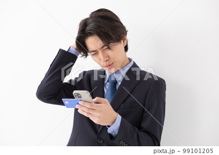 カード決済をする若い男性 スマートフォン 悩む カード決済をする若い男性 スマートフォン 悩む 99101205