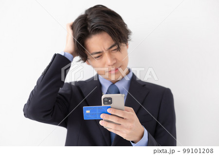 カード決済をする若い男性　スマートフォン　悩む 99101208