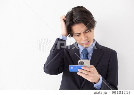 カード決済をする若い男性　スマートフォン　悩む 99101212