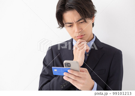 カード決済をする若い男性　スマートフォン　悩む 99101213