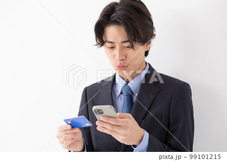 カード決済をする若い男性　スマートフォン　悩む 99101215