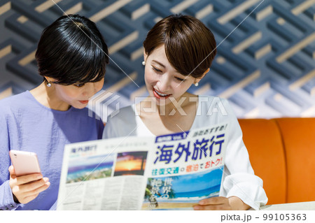 海外旅行のパンフレットを見ながら計画を立てる女性 撮影協力：WEEK芝大門(サンフロンティア不動産) 99105363