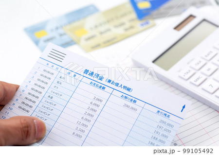 通帳の明細を見る男性の手元 通帳の明細を見る男性の手元 99105492