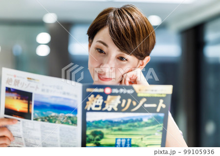 カフェで旅行のパンフレットを見る女性 撮影協力：WEEK芝大門(サンフロンティア不動産) 99105936