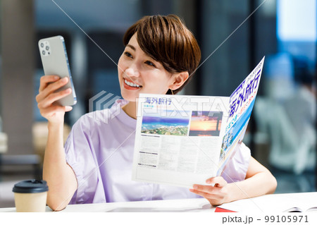 カフェで旅行のパンフレットを見る女性 撮影協力：WEEK芝大門(サンフロンティア不動産) 99105971