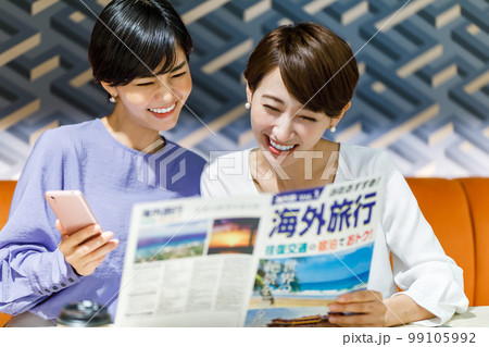 海外旅行のパンフレットを見ながら計画を立てる女性 撮影協力：WEEK芝大門(サンフロンティア不動産) 99105992