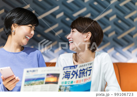 海外旅行のパンフレットを見ながら計画を立てる女性 撮影協力：WEEK芝大門(サンフロンティア不動産) 99106723