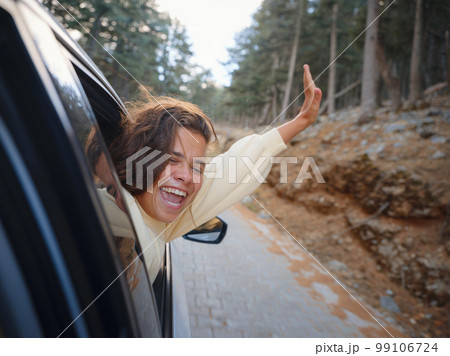 Woman on road trip traveling by rental car 99106724