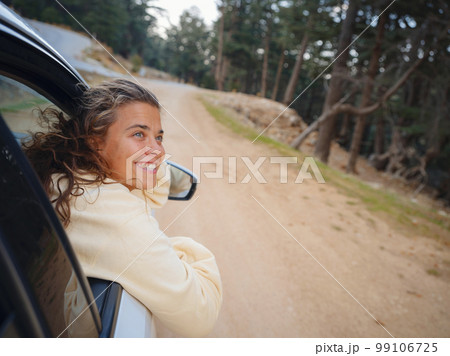 Woman on road trip traveling by rental car 99106725