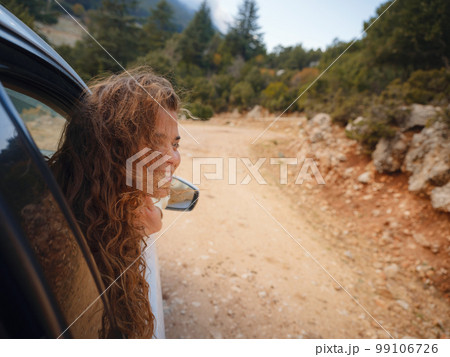 Woman on road trip traveling by rental car 99106726