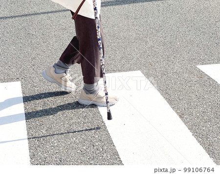 杖をついて横断歩道を渡る高齢者の足元 杖をついて横断歩道を渡る高齢者の足元 99106764