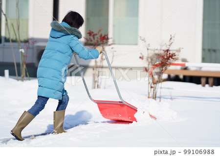 雪掻きする中年女性 99106988
