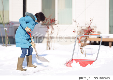 雪掻きする中年女性 99106989