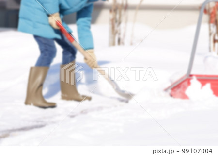 雪掻きする中年女性　顔無し　ぼかしたイメージ写真 99107004