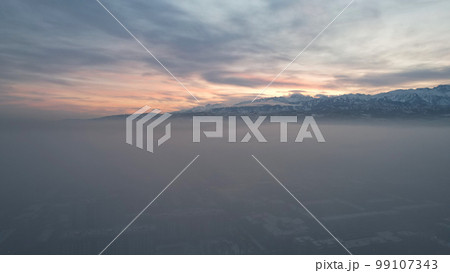 Dawn over the city in fog and smog. Mountain view 99107343