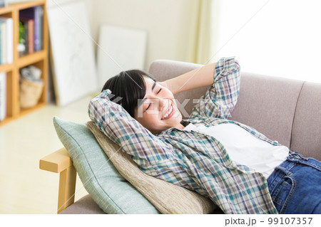 ソファでくつろぐ若い女性 リラックス 昼寝 休憩 うたた寝 ソファでくつろぐ若い女性 リラックス 昼寝 休憩 うたた寝 99107357
