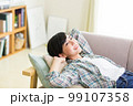 ソファでくつろぐ若い女性　リラックス　昼寝　休憩　うたた寝　 99107358