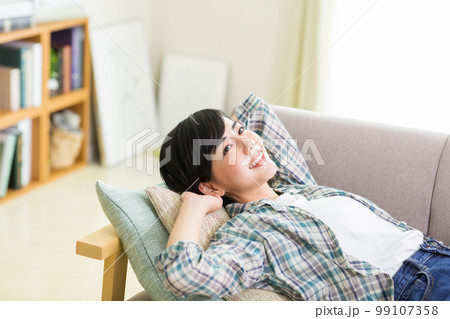 ソファでくつろぐ若い女性　リラックス　昼寝　休憩　うたた寝　 99107358