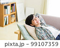 ソファでくつろぐ若い女性　リラックス　昼寝　休憩　うたた寝　 99107359