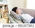 ソファでくつろぐ若い女性　リラックス　昼寝　休憩　うたた寝　 99107361