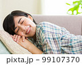 ソファでくつろぐ若い女性　リラックス　昼寝　休憩　うたた寝　 99107370