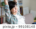 ソファでストレッチをする若い女性　リラックス　休憩　リフレッシュ　体操 99108148