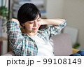 ソファでストレッチをする若い女性　リラックス　休憩　リフレッシュ　体操 99108149