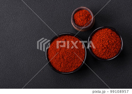 Spice smoked paprika in the form of powder in bowls and spoons Spice smoked paprika in the form of powder in bowls and spoons 99108957