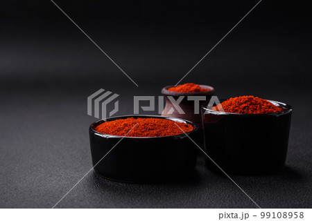 Spice smoked paprika in the form of powder in bowls and spoons Spice smoked paprika in the form of powder in bowls and spoons 99108958
