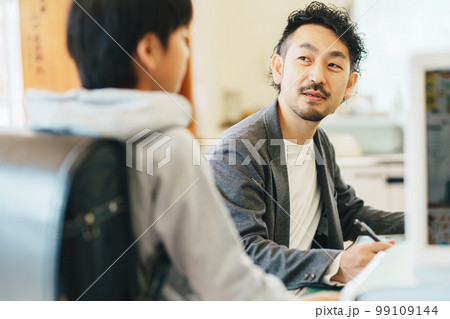 職員室で生徒の相談を受ける先生 職員室で生徒の相談を受ける先生 99109144
