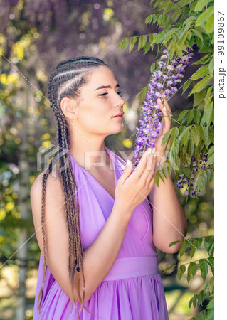 Woman wisteria lilac dress. Thoughtful happy mature woman in pur Woman wisteria lilac dress. Thoughtful happy mature woman in pur 99109867