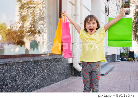The happy child with purchases on the street 99112578